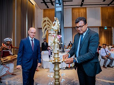 Zwei Männer stehen um eine Statue.