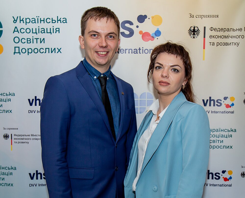 Man and woman in front of board 