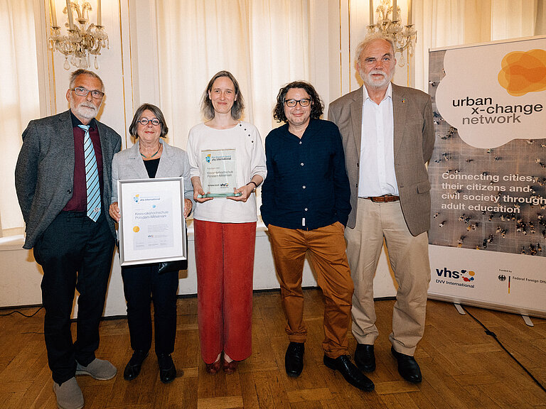 Die PreisträgerInnen der kvhs stehen nebeneinander und halten ihre Urkunde und Auszeichnung in den Händen.