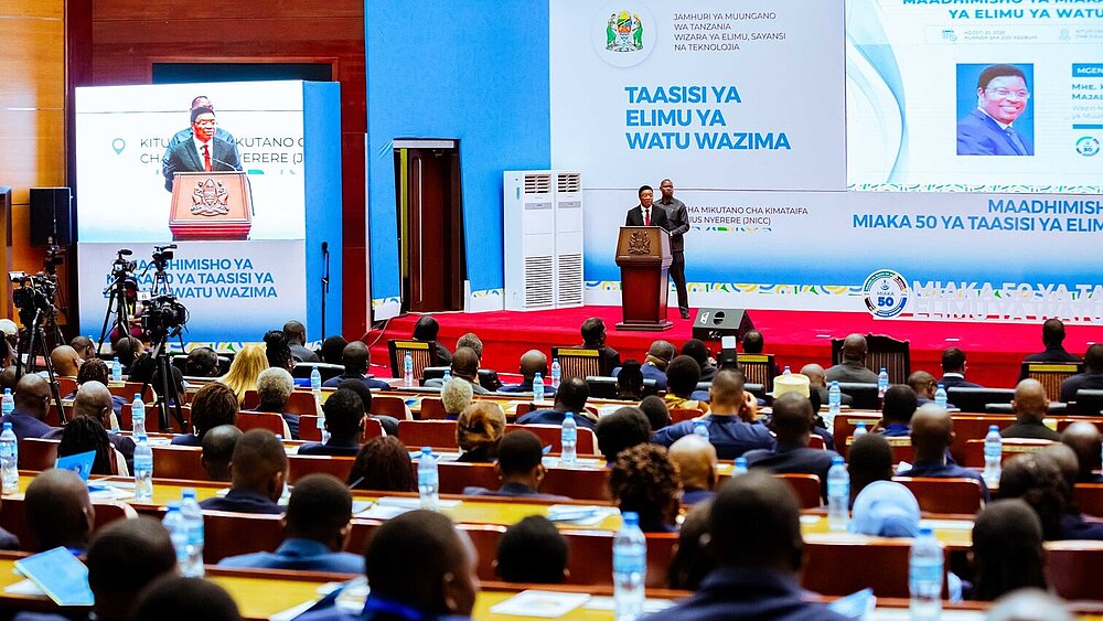 The prime minister stands in front of a speaker's podium.
