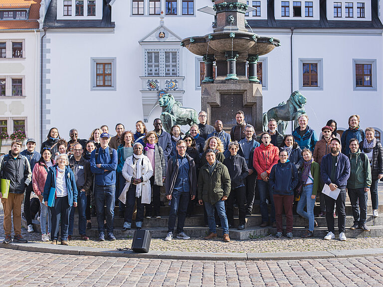 Mehrere Personen posieren für ein Gruppenbild im Freien.