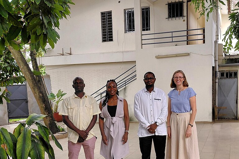 Several people are posing for a group photo.