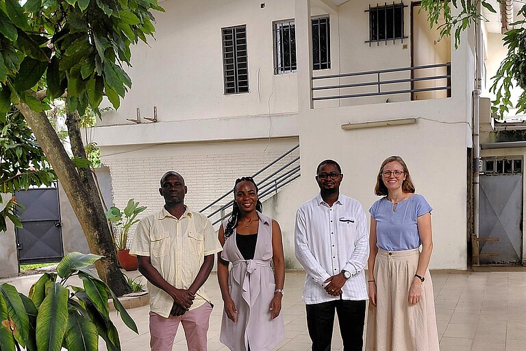 Vier Personen posieren für ein Gruppenbild.