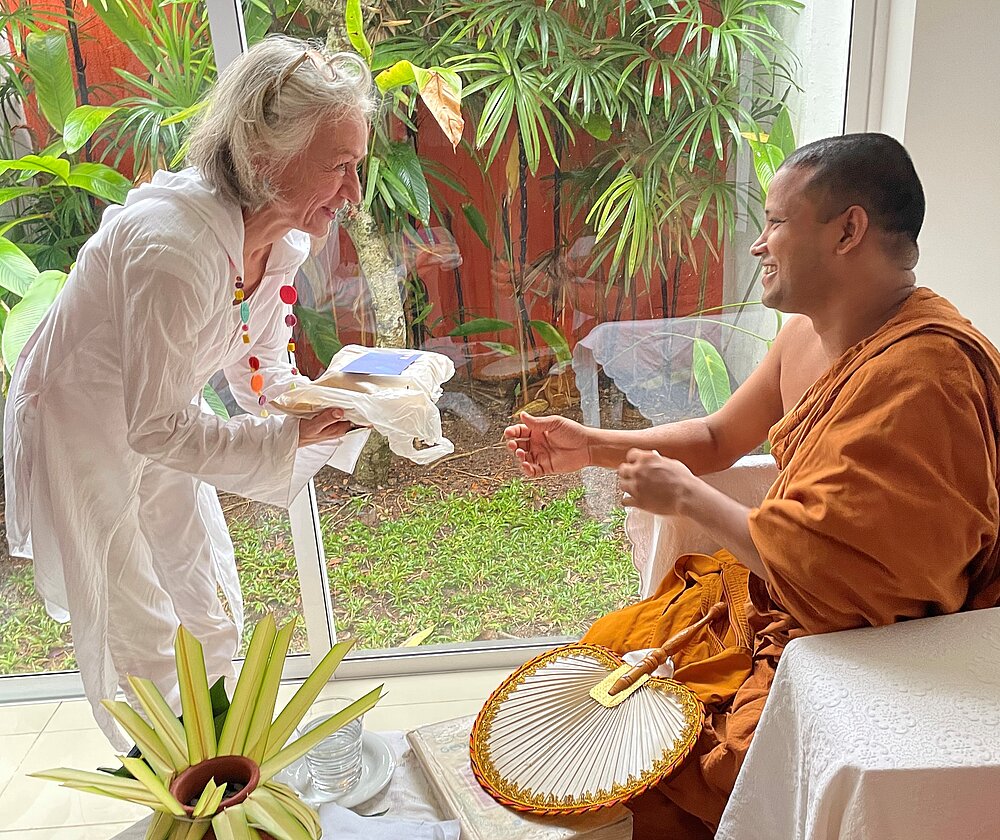Lady receiving gift from Buddhist monk