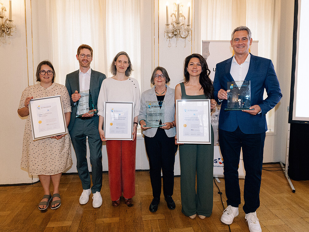 Die sechs PreisträgerInnen stehen in einer Reihe nebeneinander und halten Urkunden und Auszeichnungen in ihren Händen.