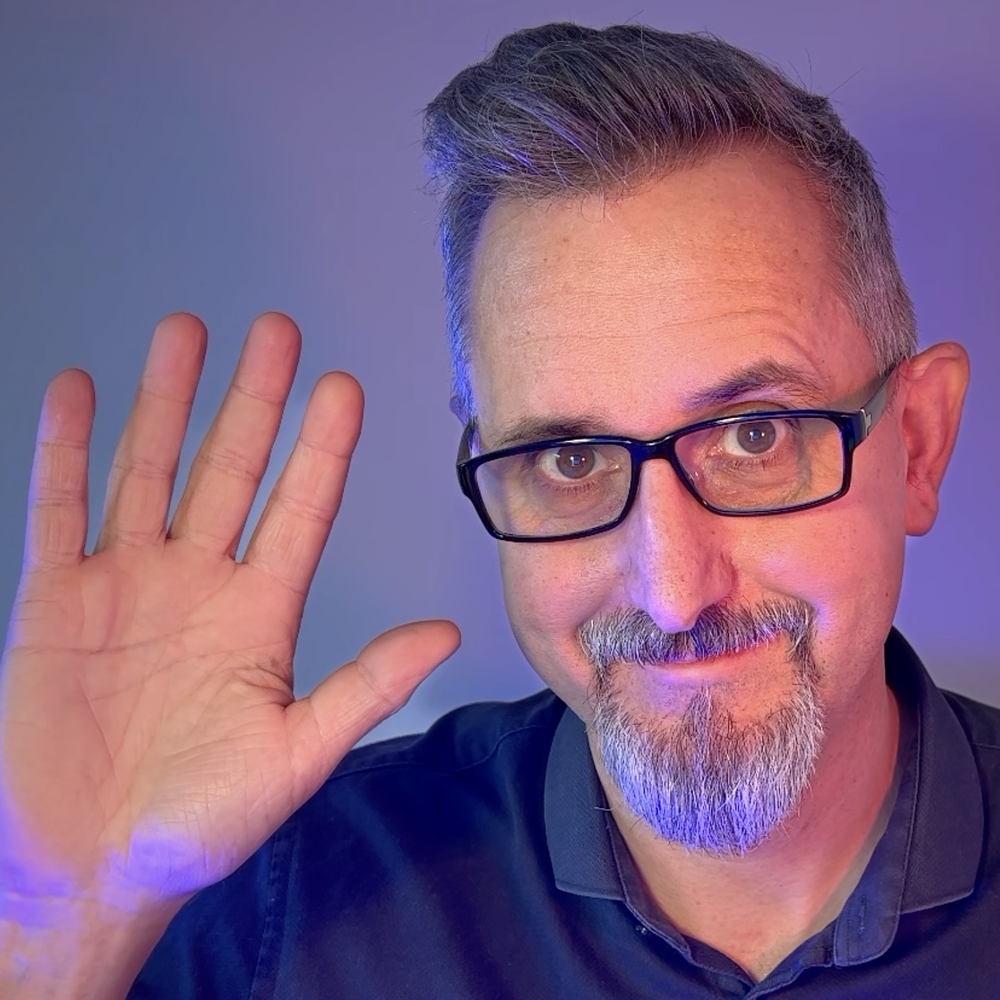 Ein Mann winkt in die Kamera.