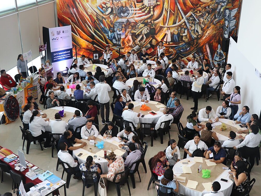 View from above of several people sitting together at round tables.