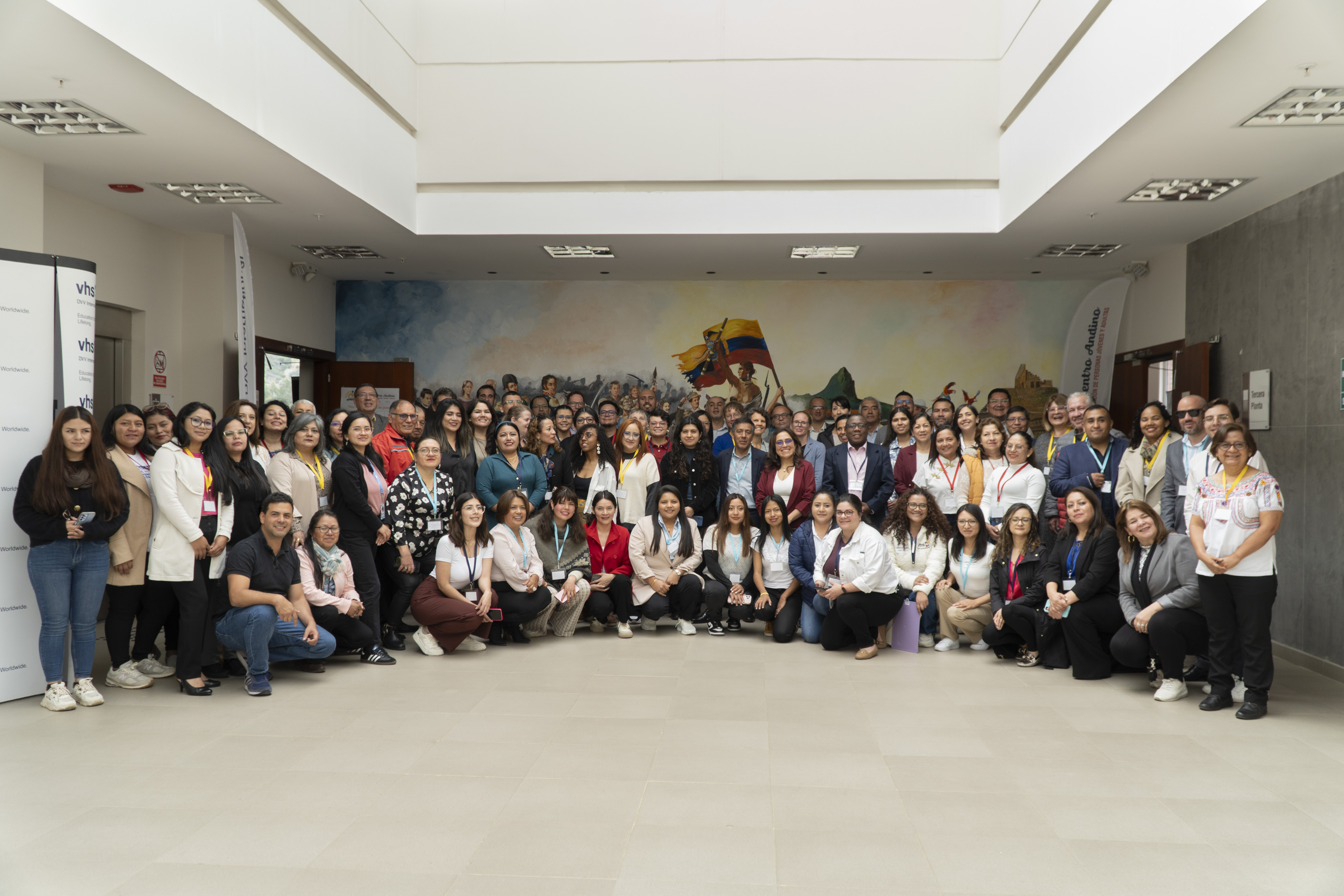 Eine große Gruppe Menschen steht für ein Gruppenfoto zusammen und blickt in die Kamera.